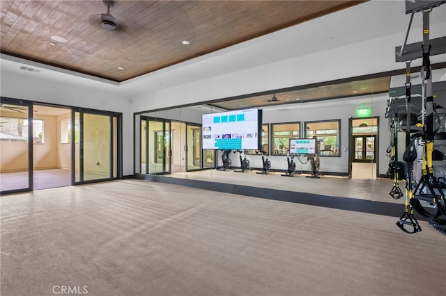 gym featuring a tray ceiling, visible vents, wooden ceiling, and baseboards