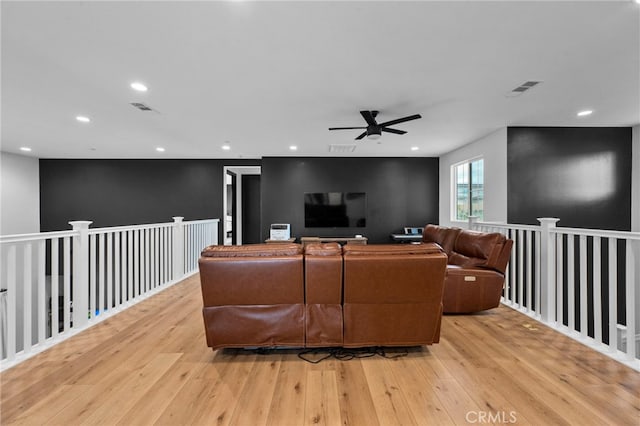 living area with light wood-style floors, a ceiling fan, and visible vents