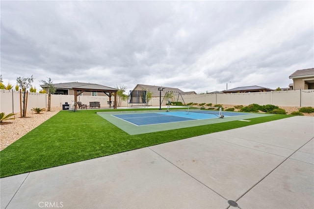 view of sport court with a gazebo, a fenced backyard, a yard, and a tennis court