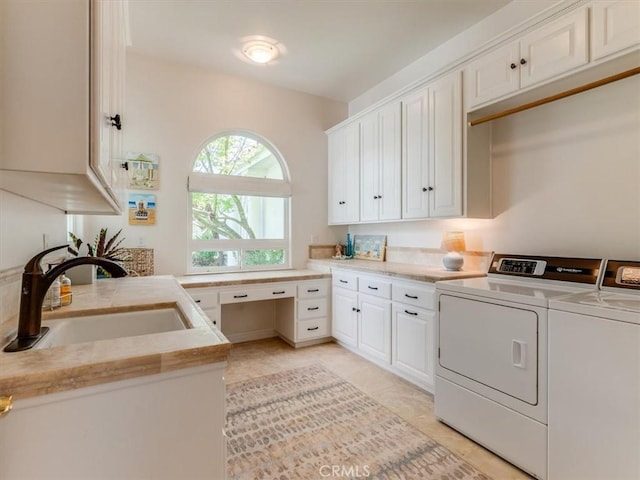 washroom featuring separate washer and dryer, a sink, cabinet space, and light tile patterned floors