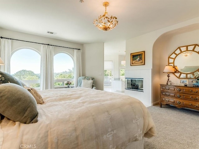 bedroom featuring carpet flooring, visible vents, and a fireplace