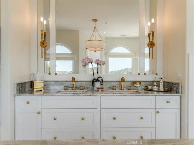 bathroom with a sink, double vanity, and visible vents