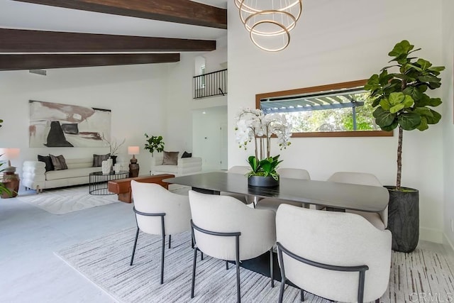 dining room featuring beam ceiling and a towering ceiling