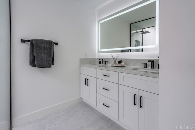 bathroom featuring baseboards, a sink, and double vanity