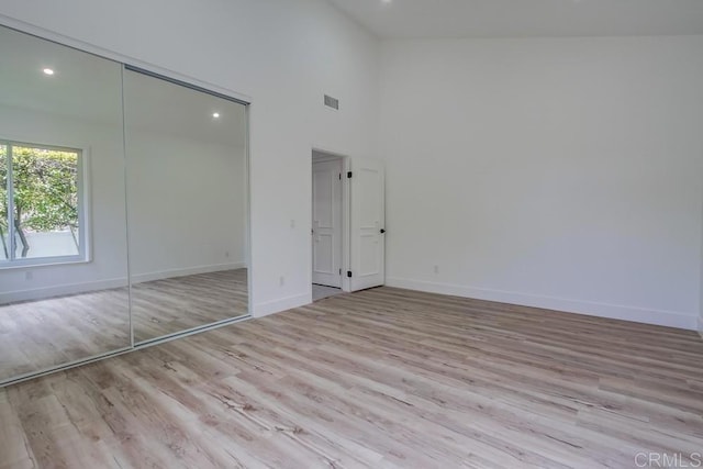 unfurnished bedroom featuring recessed lighting, baseboards, wood finished floors, and a closet