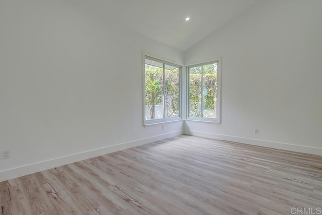 unfurnished room featuring recessed lighting, baseboards, vaulted ceiling, and light wood-type flooring