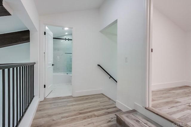 stairway with baseboards, wood finished floors, and lofted ceiling