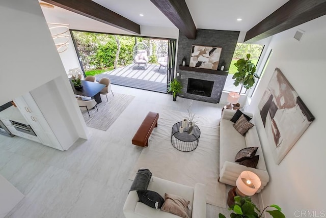 living room with a stone fireplace and beam ceiling