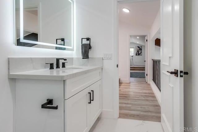 bathroom featuring baseboards, recessed lighting, marble finish floor, and vanity