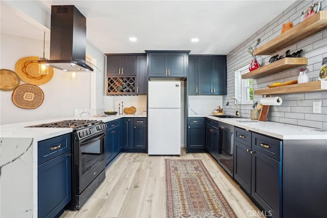 kitchen with freestanding refrigerator, light wood-style floors, island range hood, a sink, and black gas range oven
