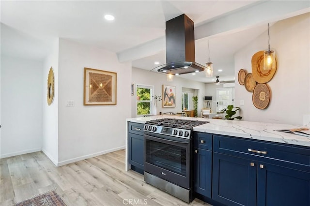 kitchen with blue cabinets, island range hood, light stone countertops, stainless steel gas range, and light wood-style flooring
