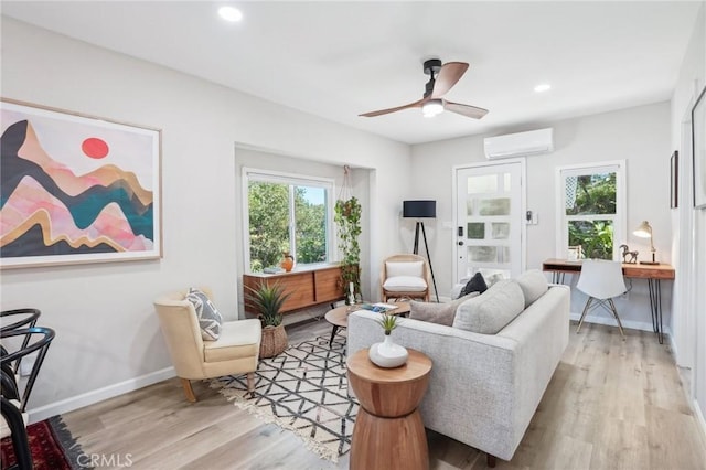 living room featuring plenty of natural light, a wall mounted AC, and light wood finished floors