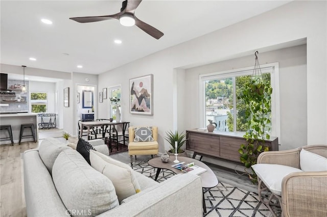 living area with light wood-style floors, recessed lighting, ceiling fan, and a healthy amount of sunlight