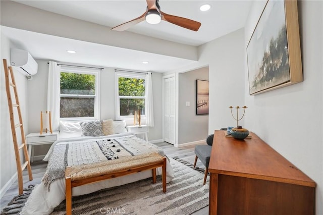 sitting room with light wood-style floors, baseboards, ceiling fan, recessed lighting, and a wall unit AC