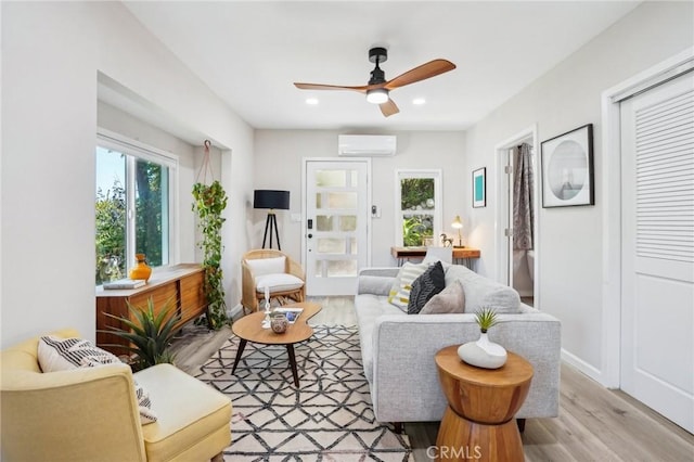 living area featuring a ceiling fan, a wall mounted AC, wood finished floors, and recessed lighting