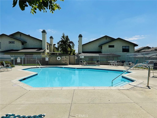pool with a patio and fence
