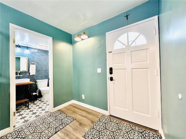 foyer entrance with baseboards and light wood-style flooring