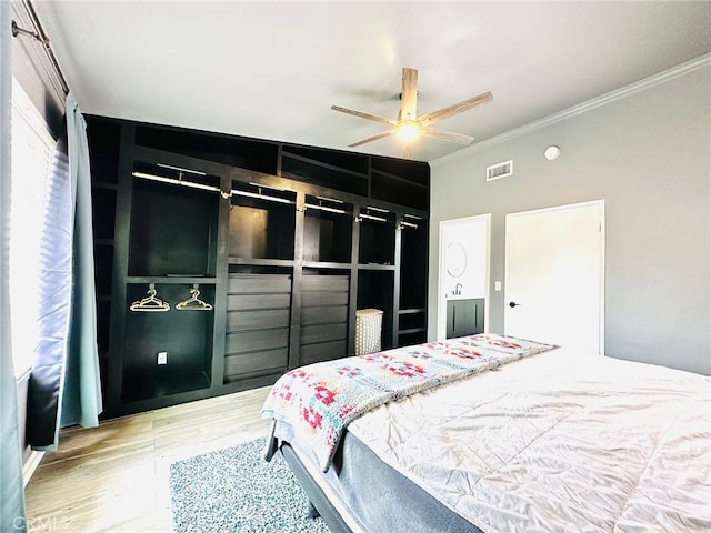 bedroom with ceiling fan, ornamental molding, wood finished floors, and visible vents