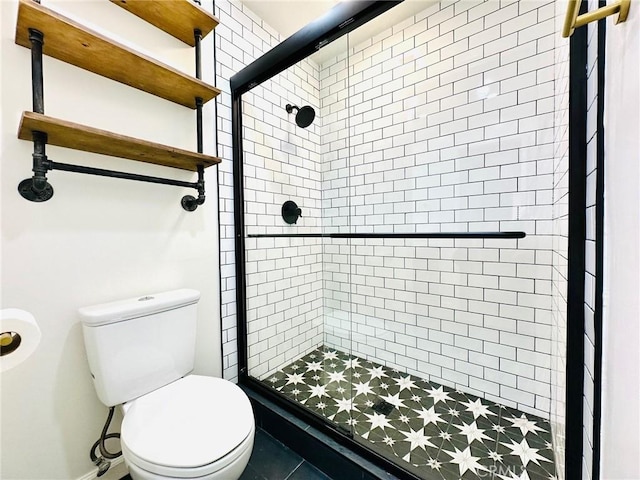 bathroom featuring toilet and a shower stall