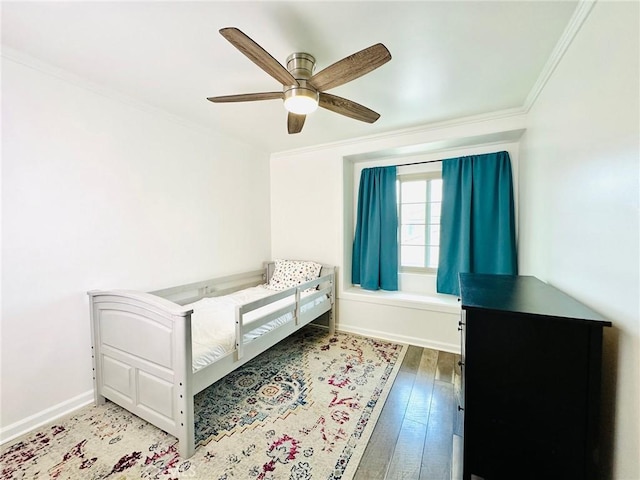 bedroom with crown molding, baseboards, ceiling fan, and hardwood / wood-style flooring