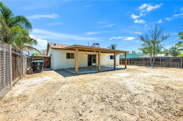 rear view of property with a patio, a fenced backyard, stucco siding, and a chimney