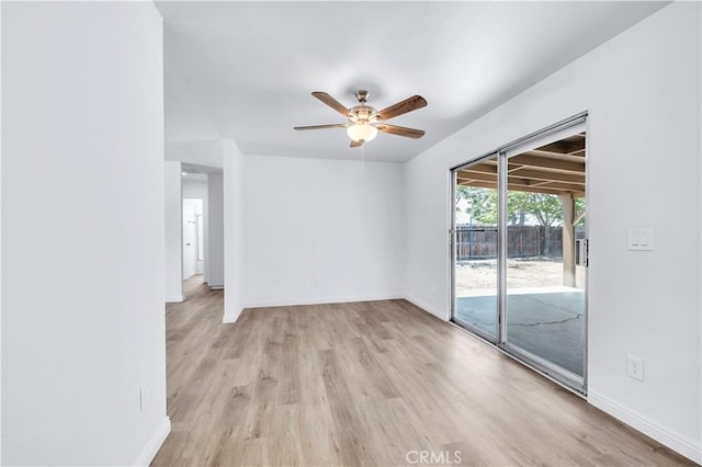 empty room featuring a ceiling fan, baseboards, and light wood-style flooring