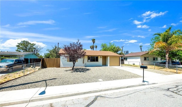 view of front of house with an attached garage, fence, and driveway