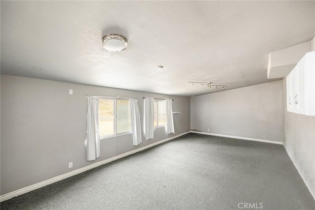 carpeted empty room featuring baseboards
