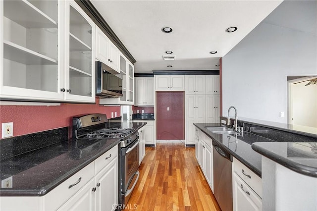 kitchen with visible vents, appliances with stainless steel finishes, light wood-type flooring, a sink, and white cabinets
