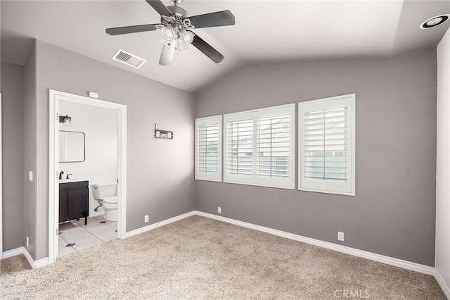 unfurnished bedroom with light colored carpet, baseboards, visible vents, and lofted ceiling