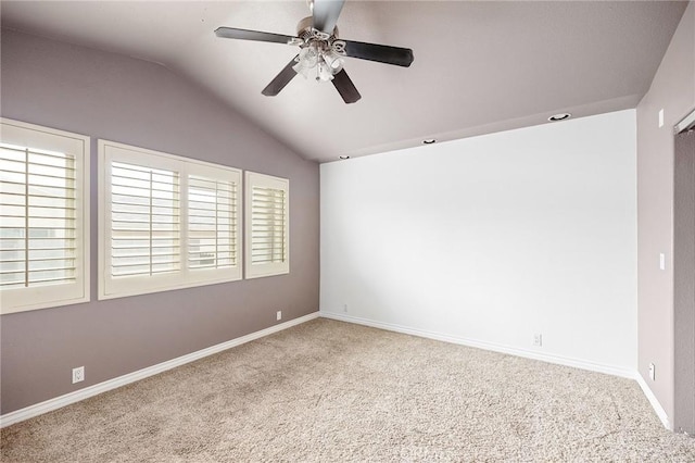 spare room featuring carpet floors, ceiling fan, vaulted ceiling, and baseboards
