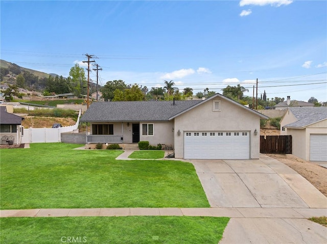 ranch-style home with driveway, a front yard, fence, an attached garage, and stucco siding