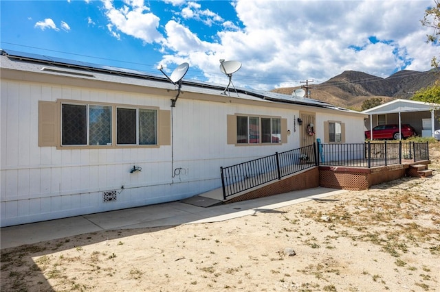 12859 Danbury St, Whitewater, CA 92282 - view of front facade with roof mounted solar panels, a mountain view, and a patio