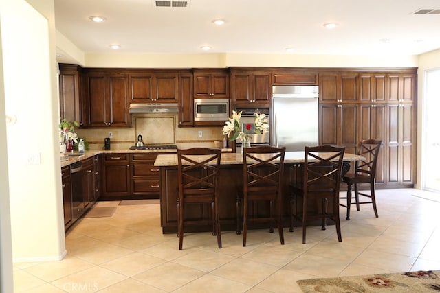1730 W Alps Dr, Upland, CA 91784 - kitchen with built in appliances, under cabinet range hood, a kitchen island, light tile patterned floors, and recessed lighting