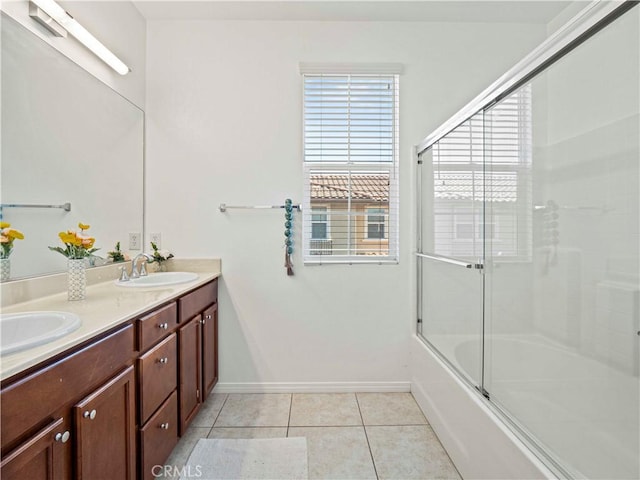 bathroom featuring a sink, baseboards, tile patterned flooring, and double vanity