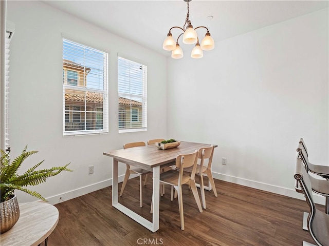 dining room featuring baseboards, wood finished floors, and a chandelier