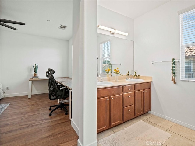 full bathroom with double vanity, ceiling fan, visible vents, and a sink