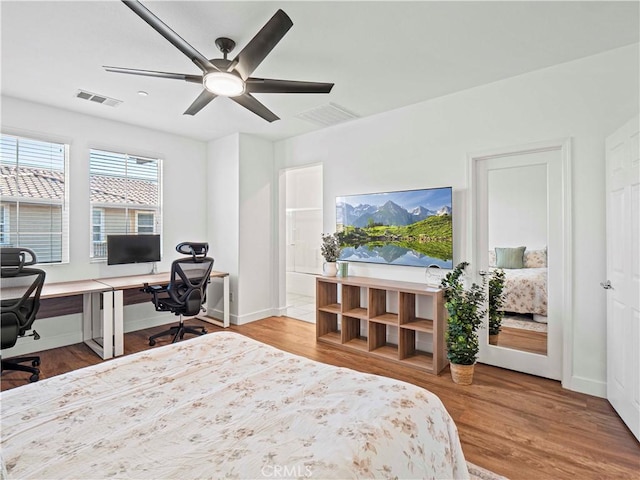bedroom with ceiling fan, baseboards, visible vents, and wood finished floors