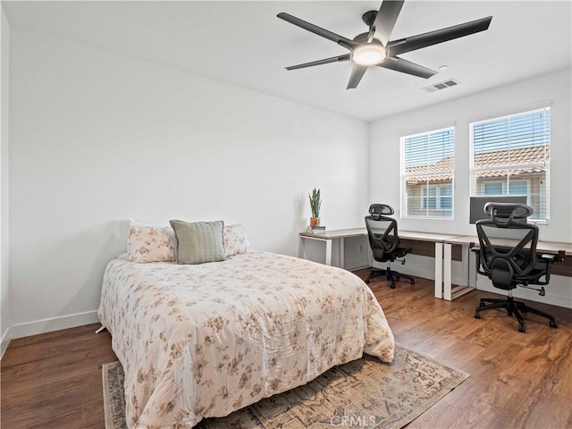 bedroom featuring ceiling fan, baseboards, visible vents, and wood finished floors