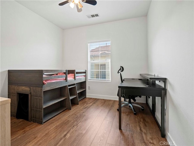 bedroom featuring visible vents, baseboards, ceiling fan, and wood finished floors