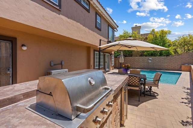 view of patio / terrace with exterior kitchen, grilling area, a fenced in pool, a fenced backyard, and french doors