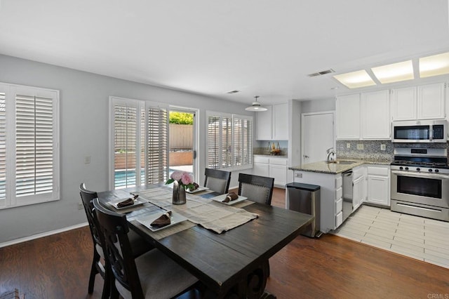 dining space featuring baseboards, light wood-type flooring, and visible vents