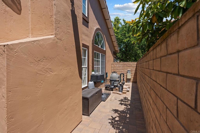 view of side of property featuring a fenced backyard, stucco siding, and a patio area