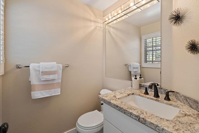 half bath featuring vanity and toilet