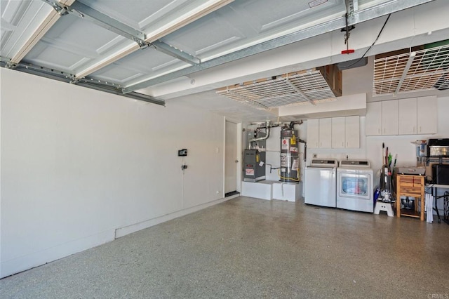 garage with washer and dryer, secured water heater, and heating unit