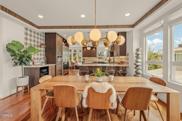 dining area with recessed lighting, baseboards, light wood finished floors, and wine cooler