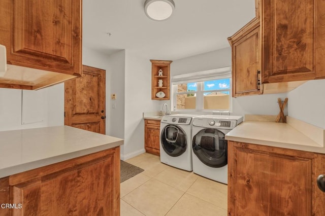 laundry area featuring separate washer and dryer, cabinet space, and light tile patterned flooring