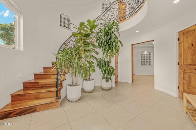 stairway with recessed lighting, baseboards, and tile patterned flooring