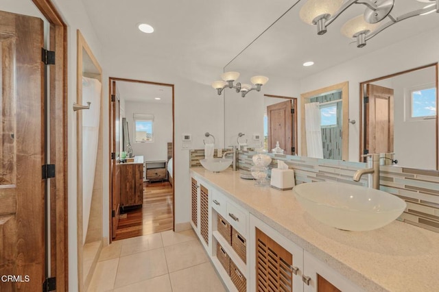 bathroom featuring tile patterned flooring, a sink, backsplash, and recessed lighting