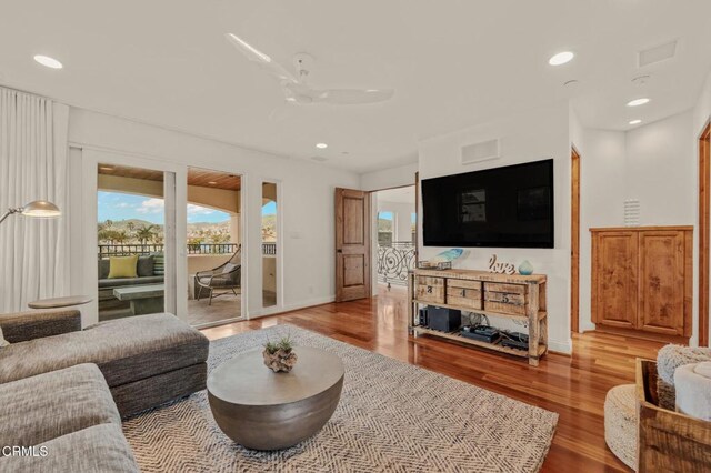 living room with a ceiling fan, baseboards, recessed lighting, and wood finished floors